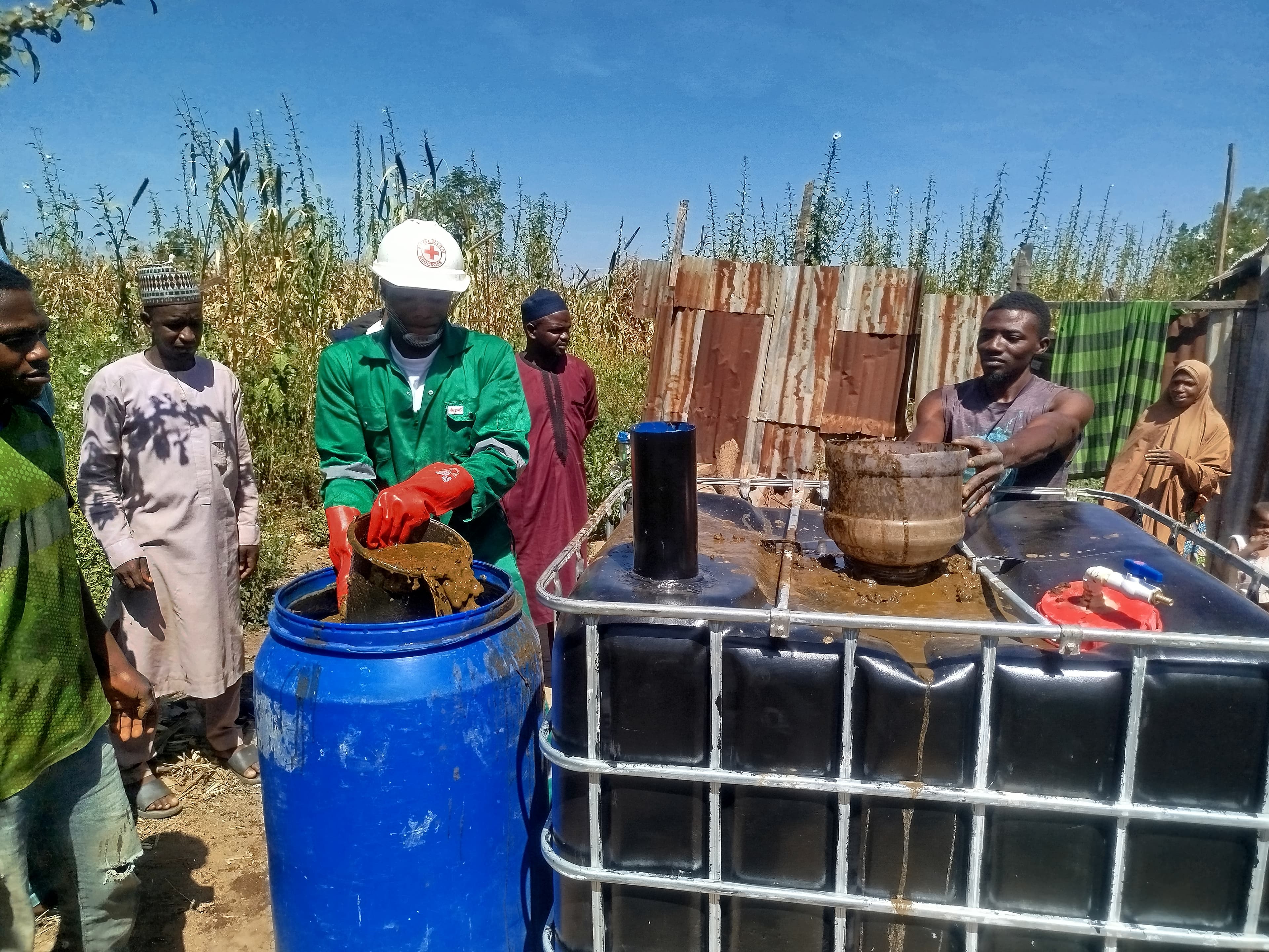 Biospark team processing organic feedstock with community members